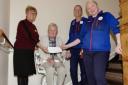 Tesco and Haylie staff at stair-lift in operation, presenting the award.