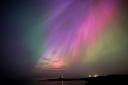 The aurora borealis, also known as the northern lights, glow on the horizon at St Mary’s Lighthouse in Whitley Bay on the North East coast (Owen Humphreys/PA)