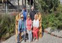 Train of thought  - Largs Station garden volunteers on new bench