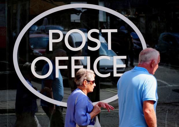 Largs and Millport Weekly News: People walking outside a Post Office. Credit: PA