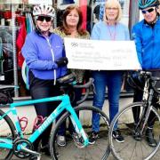Colin and Irene provide the cheque at British Heart Foundation shop in Largs