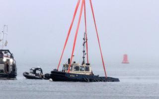 The sunken tug Biter being recovered off Greenock following the tragedy in February 2023 that claimed the lives of Ian Catterson and George Taft