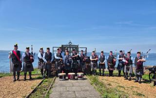 The Isle of Cumbrae Pipe Band at war memorial on Cumbrae